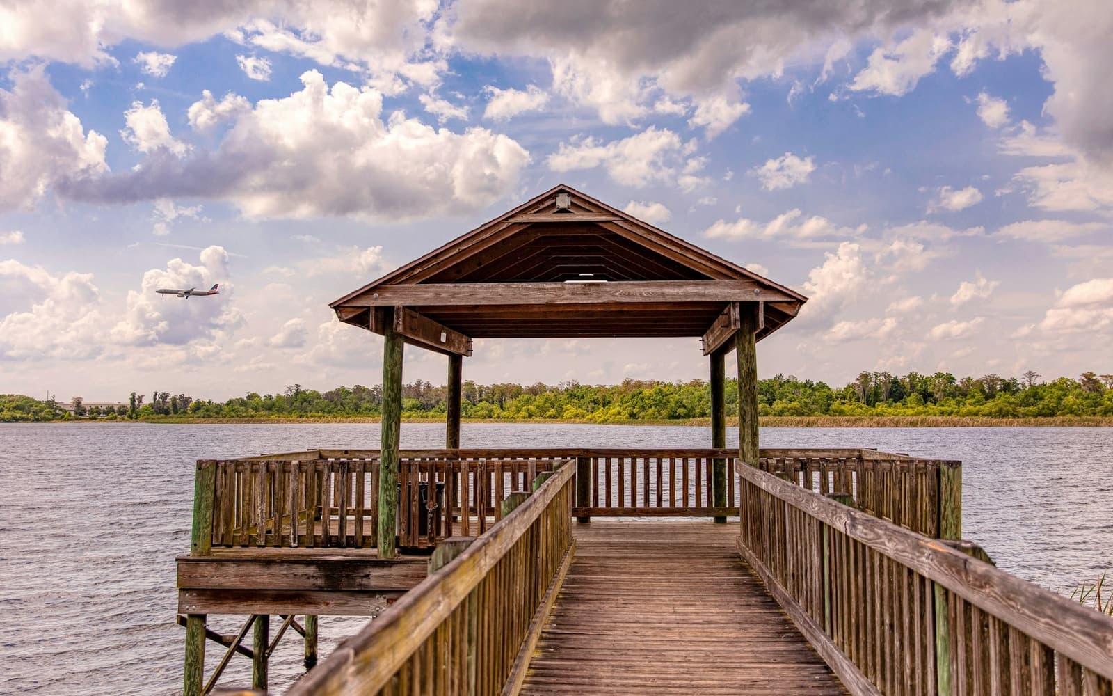 A covered wooden dock on a wide river