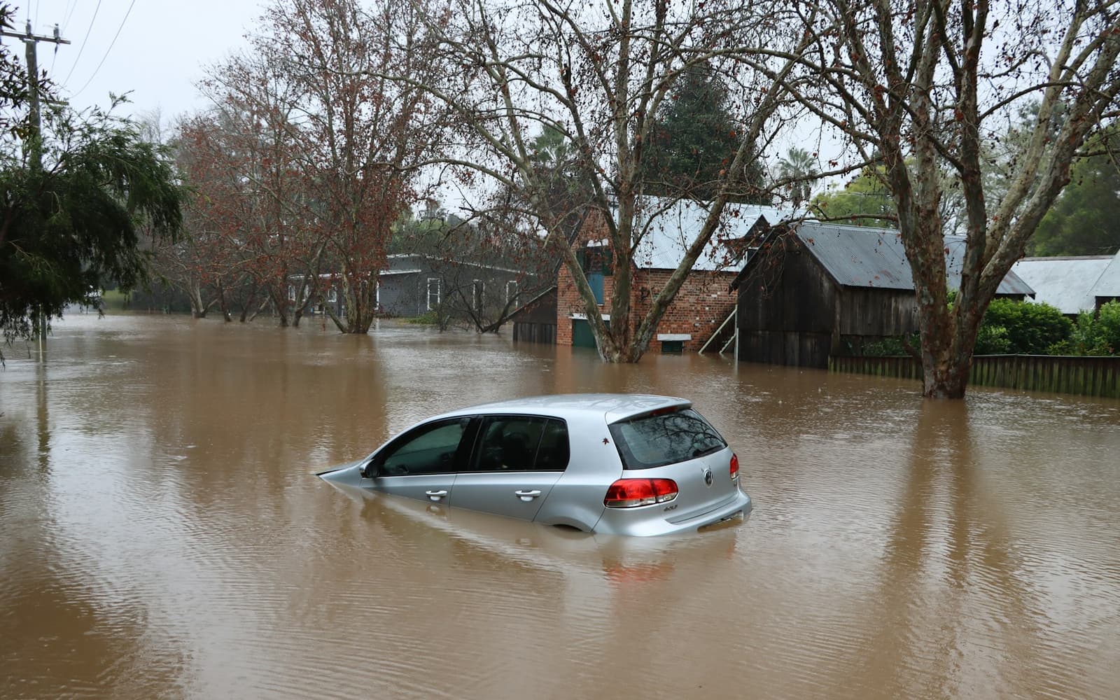 A car and houses in floodwater on a residential street