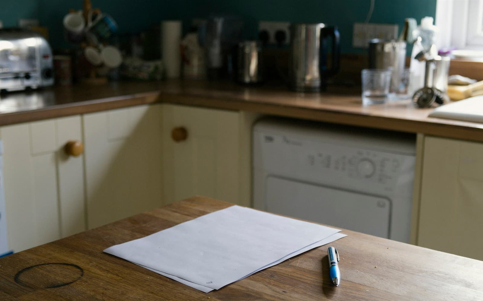 A sheet of paper and a pen on a kitchen table